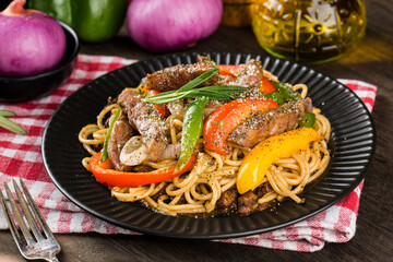 A plate of delicious pasta with beef and green pepper