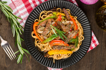 A plate of delicious pasta with beef and green pepper