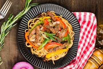 A plate of delicious pasta with beef and green pepper