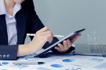 Close up hand of Business woman use devices tablet and laptop manage finances, analyze diagrams statistics in office.