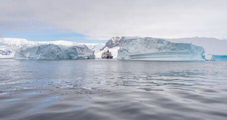 Expeditionsschiff vor antarktischer Eisberg Landschaft bei Portal Point welches am Zugang zu...