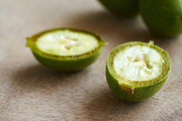Fresh green unripe walnuts on a table, close up