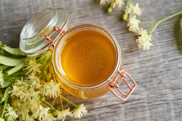 A jar of honey with fresh linden blossoms
