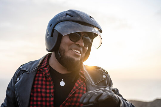Latin man motorcyclist look the desert at sunset.