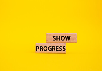 Progress symbol. Wooden blocks with words Show progress. Beautiful yellow background. Business and Show progress concept. Copy space.
