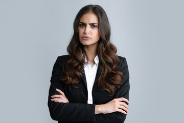 Negative business woman isolated over gray background. Displeased angry businesswoman blocking offer, showing cross stop gesture, negative reply.
