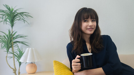 コーヒーを飲みながらくつろぐ女性