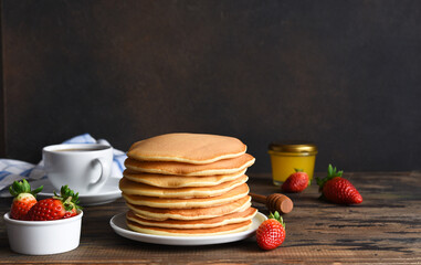Stack of pancakes. Homemade pancakes with berries for breakfast on a dark background