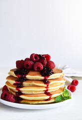 Homemade pancakes with raspberries and jam for breakfast 