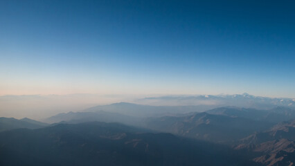 Vista de la Cordillera de los Andes con bruma, al atardecer de otoño, toma hecha desde un avion
