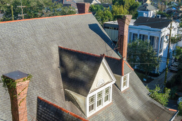 Aerial view of rooftop of historic homes showing sloped roof, vintage chimneys and dormer attic...