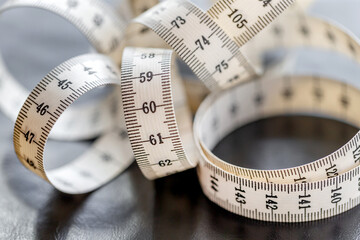 Measuring tailor tape, closeup. Spiral ruler. Fashion length measurement instrument.