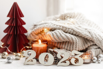 Fototapeta na wymiar Christmas background with decorative numbers 2023 and cozy details.