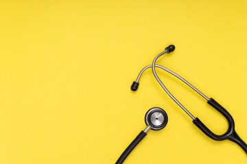black stethoscope, yellow isolated background