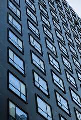 Obraz premium Repeating shapes of windows of a new modern architecture office building. Great texture and background for corporation headquarters offices.