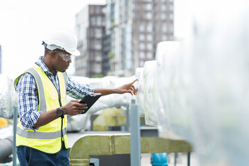Male engineer or male technician work with digital tablet at construction site area. African...