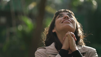 Grateful woman having HOPE praying to God. Spiritual girl smiling to sky
