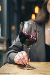 A glass of red wine in a restaurant on a table close-up.
