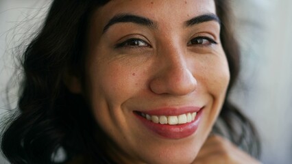 One hispanic latin young woman closeup face smiling at camera. Portrait of a happy South American person