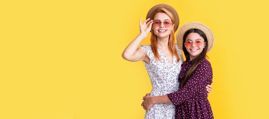 Mother and daughter kid banner, copy space, isolated background. mother and daughter smile in straw hat on yellow background.