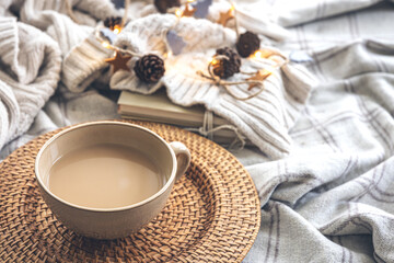 Cozy autumn composition with a big cup of coffee in bed.