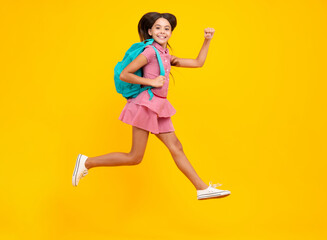 Fototapeta na wymiar Schoolgirl in school uniform with backpack. Teenage girl student on yellow isolated background. School leisure. Crazy run and jump. Learning and education children.