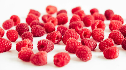 Fresh red raspberries on a white table background