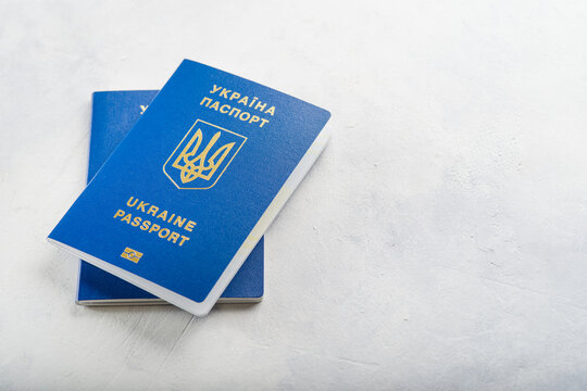 Two Ukrainian passports on a white background. Minimalism. There are no people in the photo. There is free space to insert. Emigration, business, travel, flight from war in Ukraine.