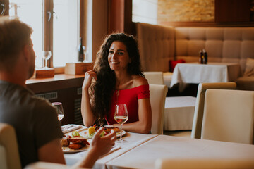 Young couple having lunch with white wine in the restaurant