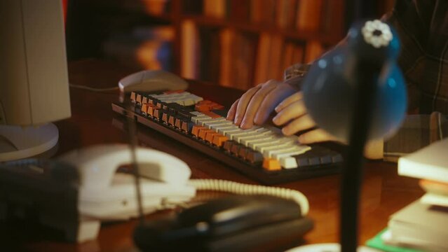 Hands of 90s IT specialist typing on vintage computer keyboard, retro office
