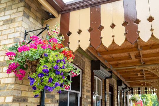 Beautiful Hanging Basket Seen At The Corner Of A Steam-era Railway Station. The Ornate, Victorian Canopy To The Railway Ticket Office Is Clearly Visible.