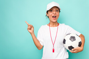 Young hispanic soccer referee woman isolated on blue background pointing to the side