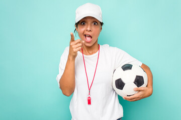 Young hispanic soccer referee woman isolated on blue background having an idea, inspiration concept.