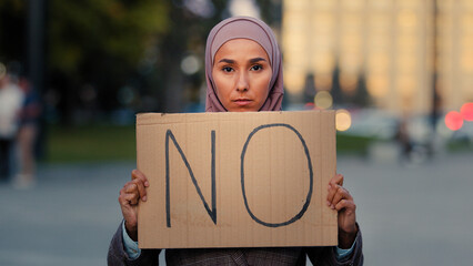 Stop racism No concept Arab immigrant Muslim woman in hijab protests against discrimination vax...