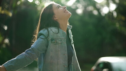 Carefree happy woman arms raised outside looking at sky feeling grateful. Person celebrating life...
