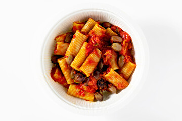 Italian tortiglioni pasta puttanesca with tomato sauce and black olives on the white table in a box for delivery