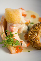 Prawn in creamy sauce, with red caviar, herbs and citrus dairy foam, and seed bread.
