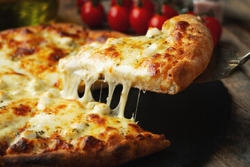 A slice of hot Italian pizza with stretching cheese. Pizza four cheeses with basil. - obrazy, fototapety, plakaty