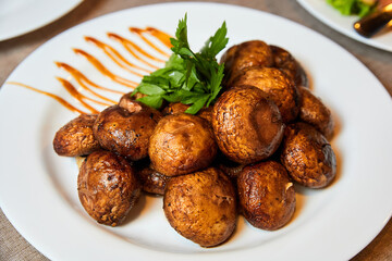 Grilled mushrooms with herbs on a white plate