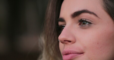 Fototapeta premium Young woman opening eyes. Close-up of girl face with green eyes looking at horizon thinking about life in meditative contemplation
