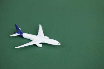 Fototapeta na wymiar Miniature toy airplane on green background. Summer holiday air travel by plane concept.