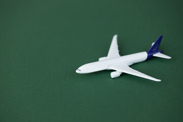 Miniature toy airplane on green background. Summer holiday air travel by plane concept.