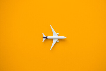 Flat lay design of travel concept with plane on yellow background