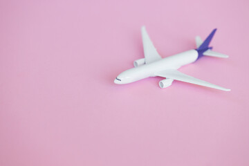 Travel concept on pink background with copy space. Airplane toy on pink color background.