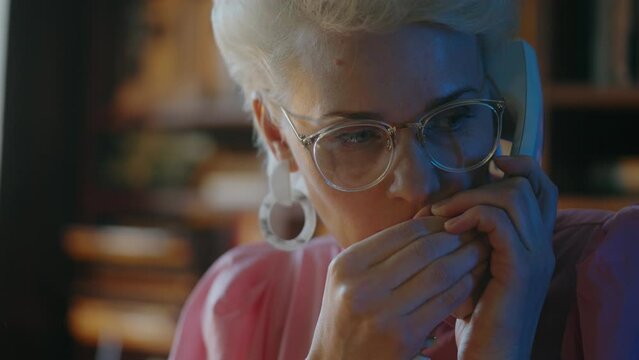 Scared female spy telling secret business information on phone, looking around
