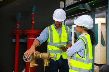 Construction project engineer check and discussing at front of fire Fighting valve or fire...