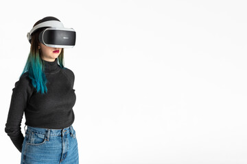 A teenager girl in a vr helmet plays in the virtual universe isolated on a white background, vertical frame. The concept of the virtual universe. Lifestyle in the virtual space