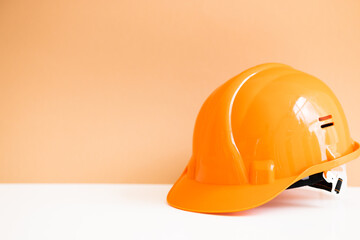 Orange protective safety helmet on color background