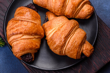 Crispy chocolate croissant with Christmas decorations on wooden cutting board