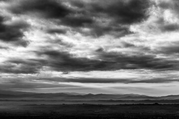 View of Umbria valley beneath a big, dramatic cloudy sky